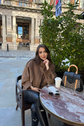 a lady in a brown tencel wool coat and a pair of black leather pants